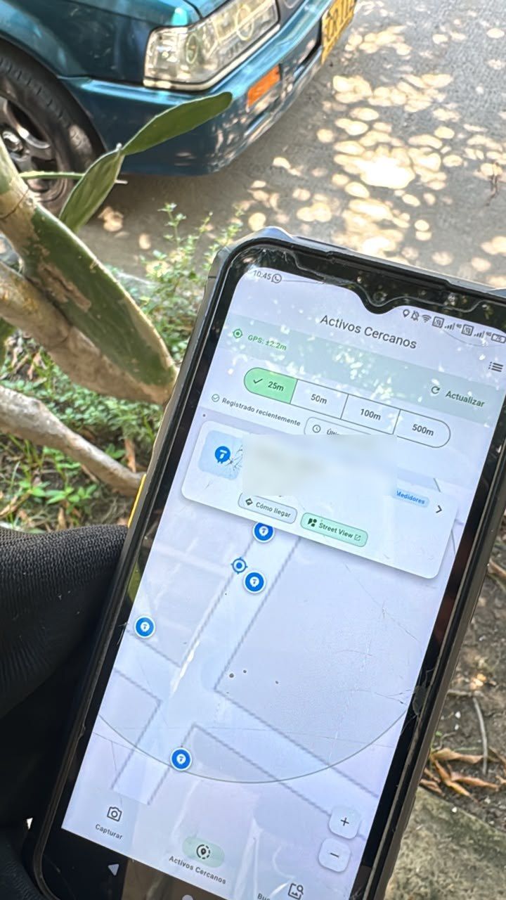 Celular en campo mostrando el mapa de activos cercanos de la app Captura